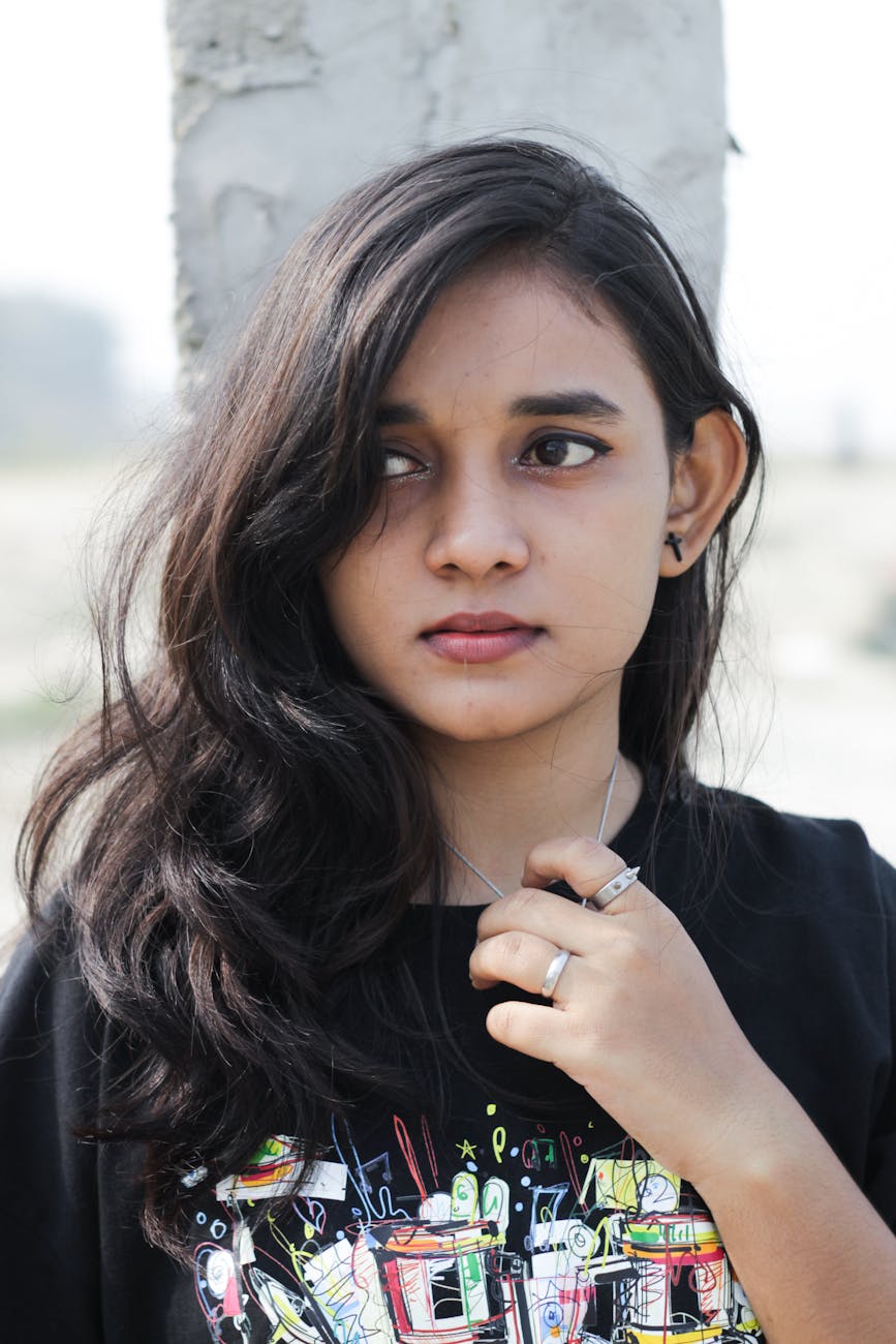 Portrait of a young woman with long black hair wearing a t-shirt, shot outdoors in Patna, India.